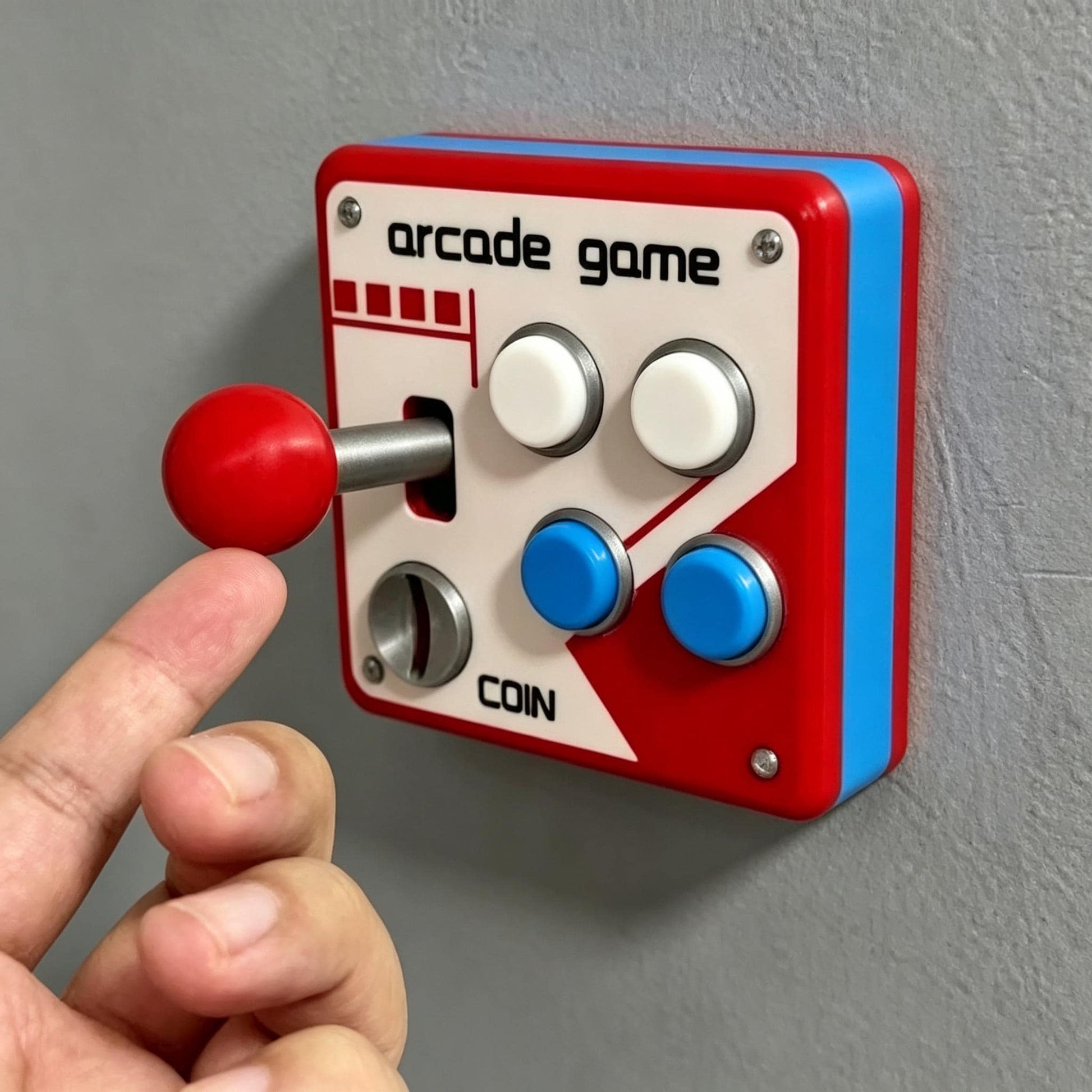 May include: A wall-mounted arcade game controller featuring a red joystick, two white buttons, and two blue buttons. The white faceplate displays the text arcade game and coin with a silver coin slot. The unit has a red and blue plastic frame.